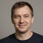 Улыбающийся мужчина, изучивший руководства Computers Plus MI по правилам отыгрыша в онлайн-казино для новичков
